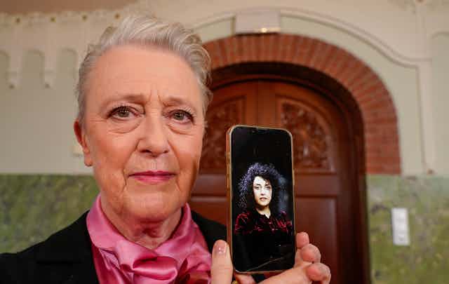 Nobel committee chair Berit Reiss-Andersen holds up a phone with a picture of 2023 Nobel peace prize winner Narges Mohammadi.