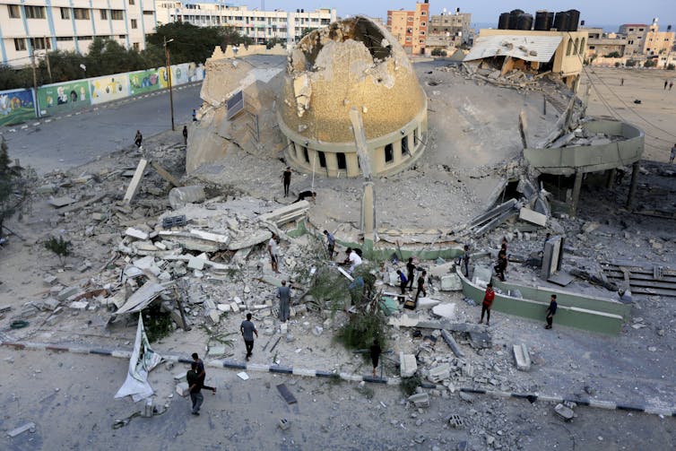 Building with a golden dome that's damaged, surrounded by rubble.