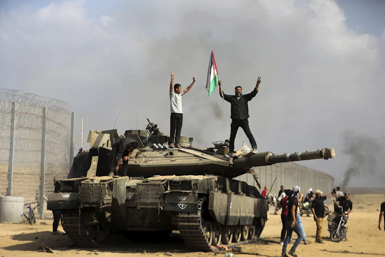 Hommes brandissant un drapeau palestinien sur un char