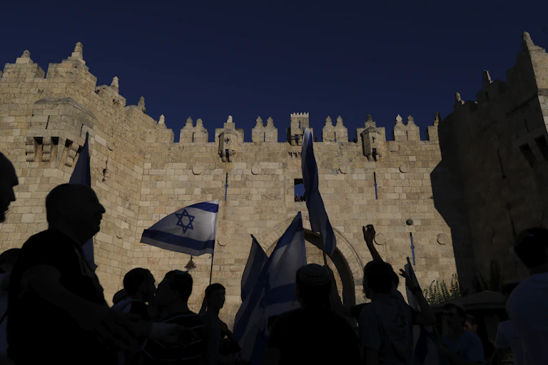 Demonstrators in silhouette in front of the Damascus gate