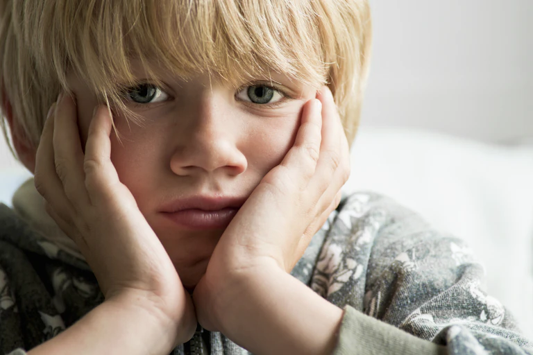 Sad looking young boy close to camera
