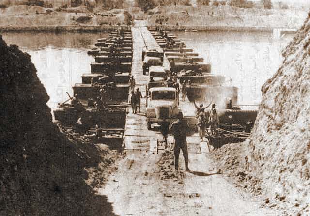 Camions militaires égyptiens franchissant le canal de Suez sur un ponton le 7 octobre 1973, pendant la guerre du Kippour.