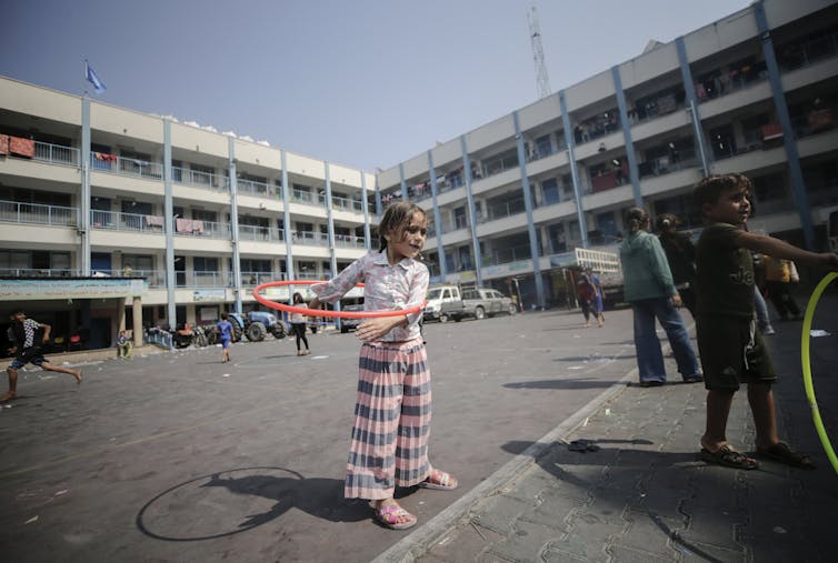 Small child playing with a hula hoop.