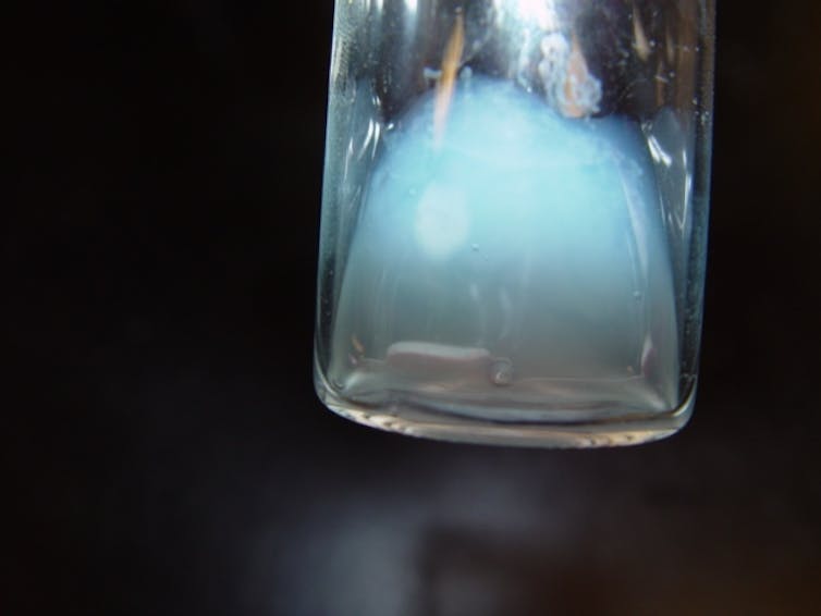A vial partly filled with pale blue fluid