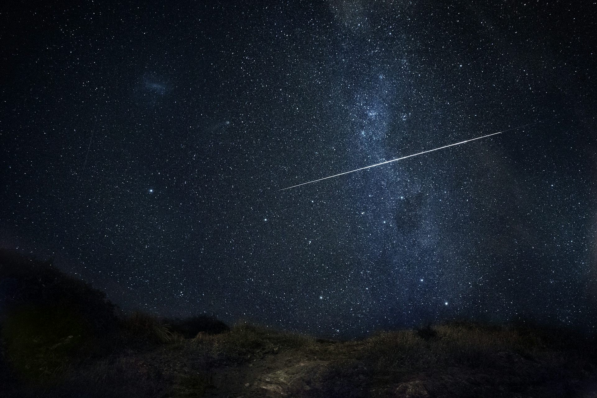 A bright shooting star with the Milky Way in the background