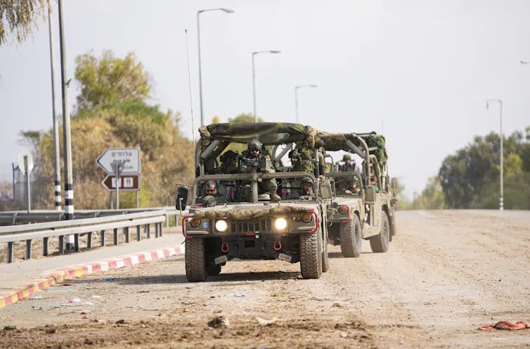 A military truck carrying armed soldiers.