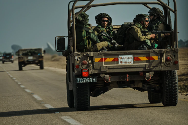 A group of armed soldiers are riding in the back of a jeep.