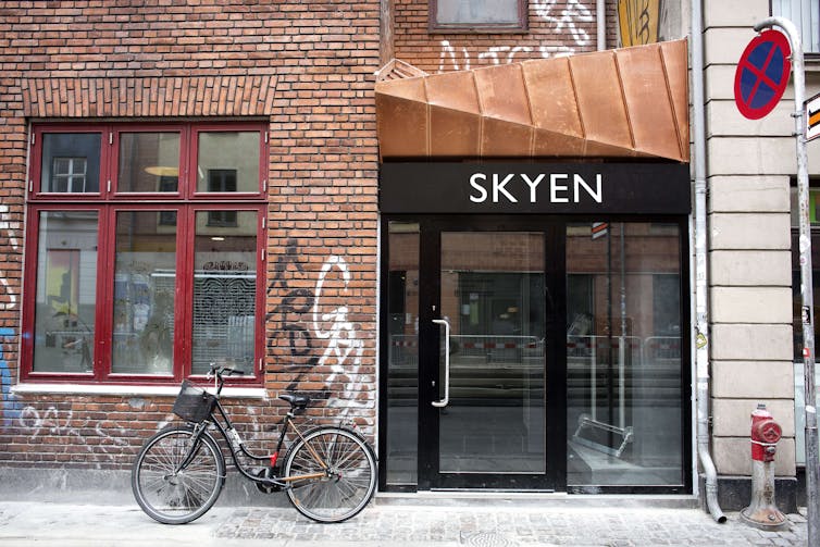 A pleasant, urban entry has a sign reading