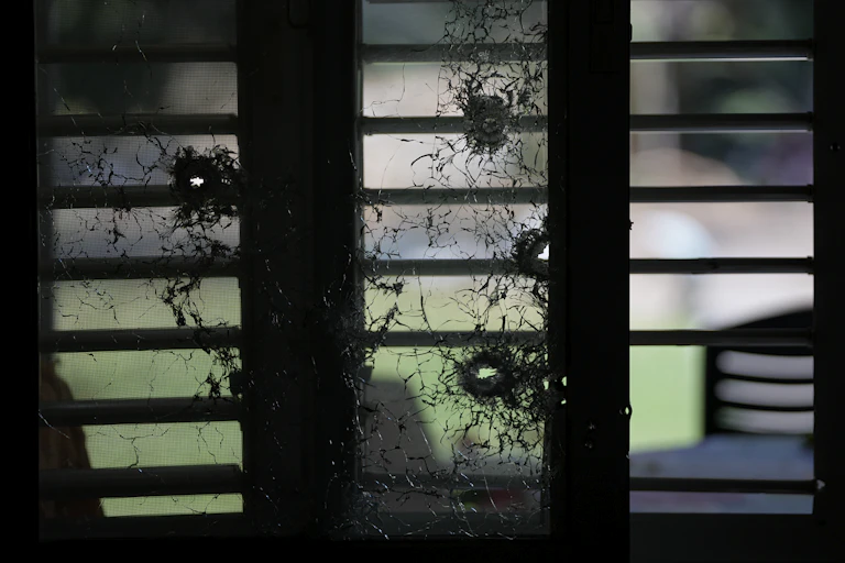 A bullet-riddled glass window.