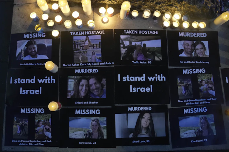 Signs on a board with photos of people and labels saying 'MISSING,' 'TAKEN HOSTAGE' or 'MURDERED.'