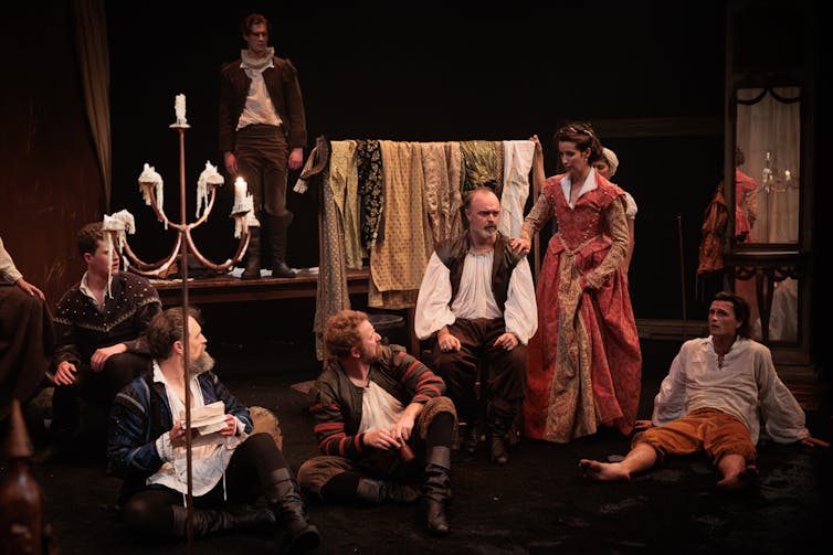 People sit around on a stage.