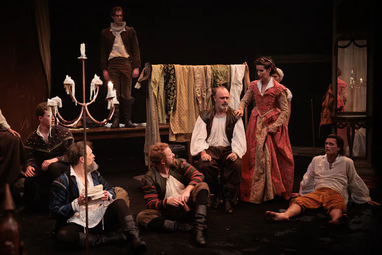 People sit around on a stage.