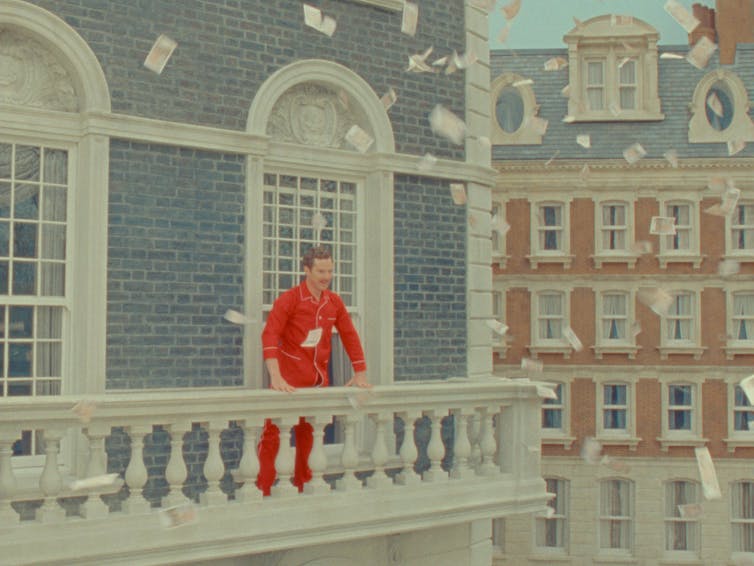 A man stands on a balcony.