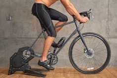 A man's legs on a stationary bike.