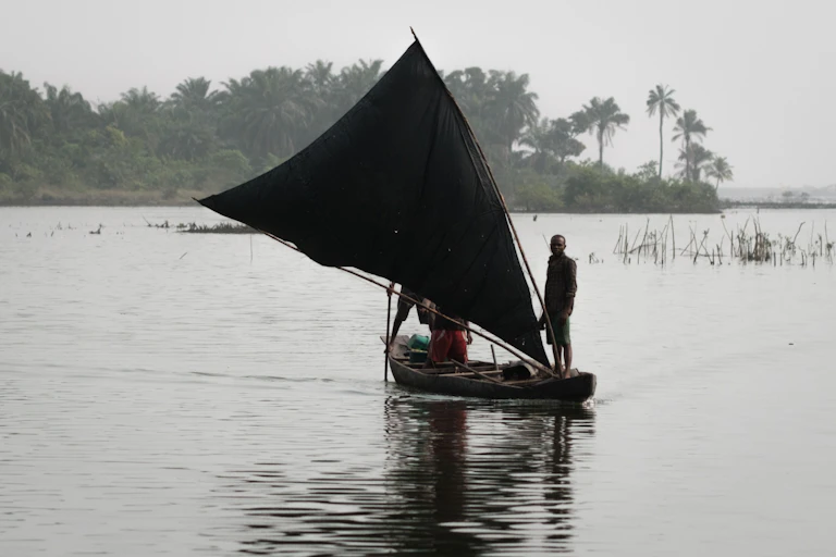 Man stands on sailing boat on a river
