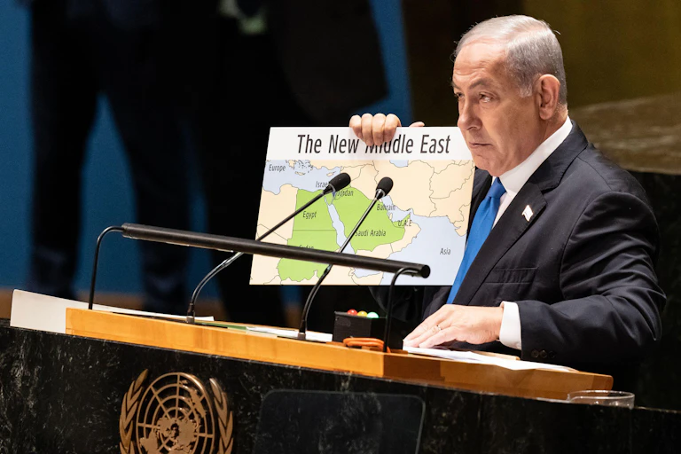 Israeli politician in suit holding map of 'New Middle East'.