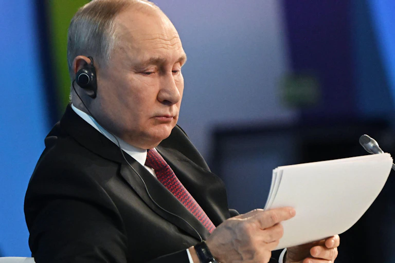 President Putin reading a paper in front of a microphone.