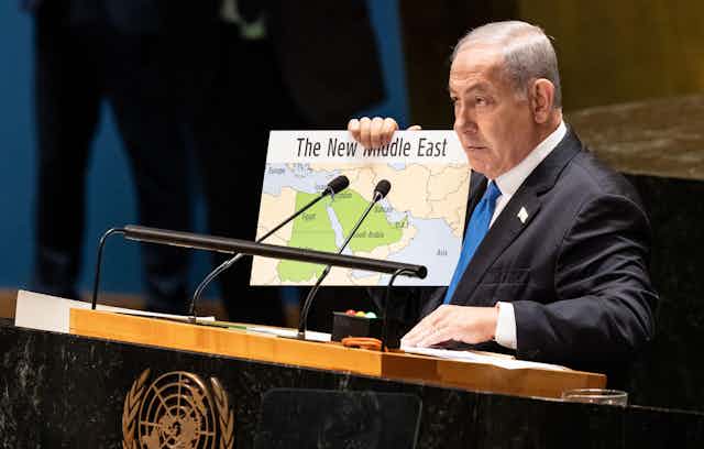 Político israelense de terno segurando o mapa do "Novo Oriente Médio".