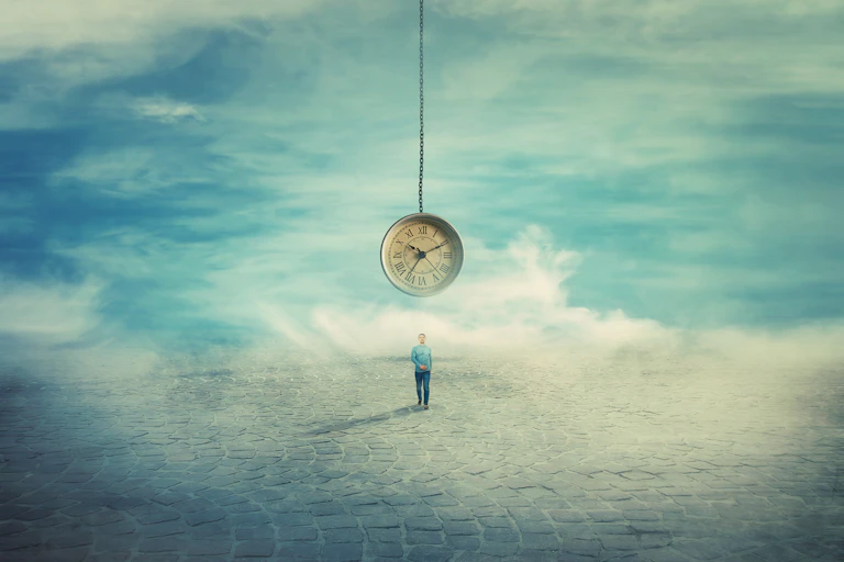 a man walks through a barren landscape, an analogue clock is suspended over him