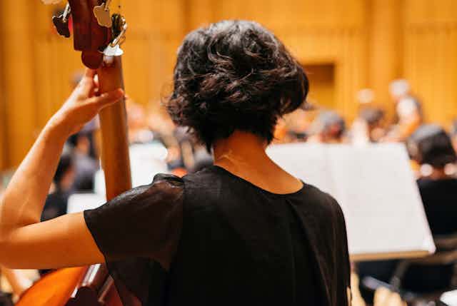A woman plays a cello. 