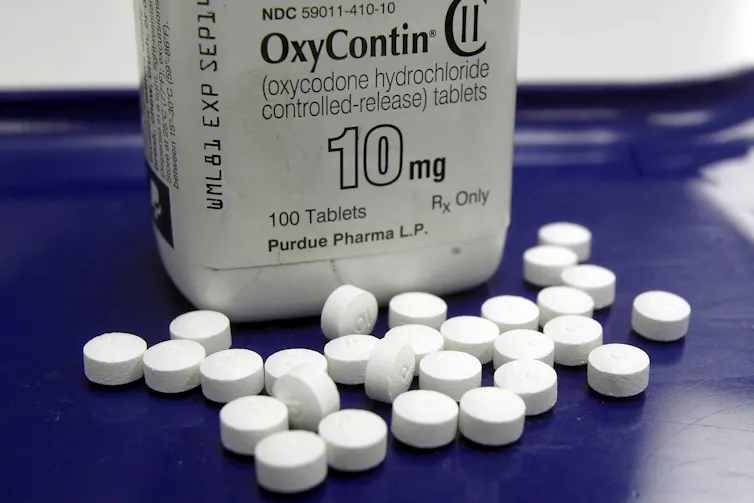 A bottle marked OxyContin 10-milligram behind a small pile of tablets