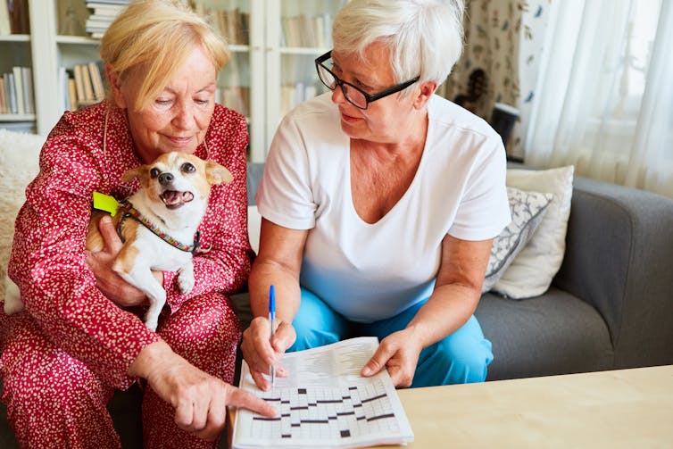 Two senior women doing a crossword.