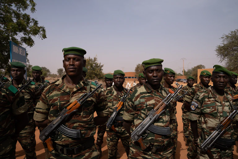 Des hommes portent des uniformes militaires, le fusil en bandoulière