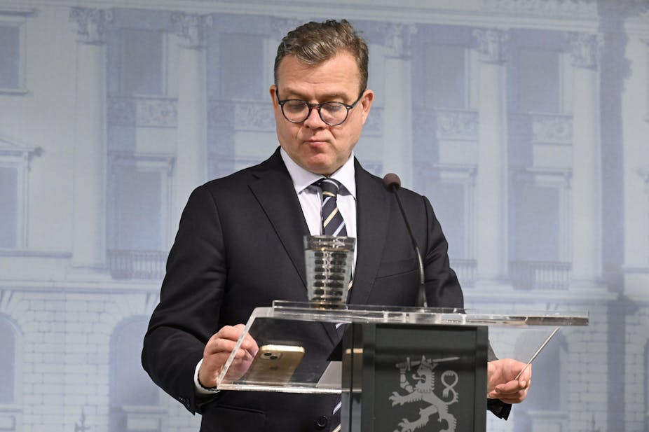 Finnish prime minister Petteri Orpo stands at a podium.
