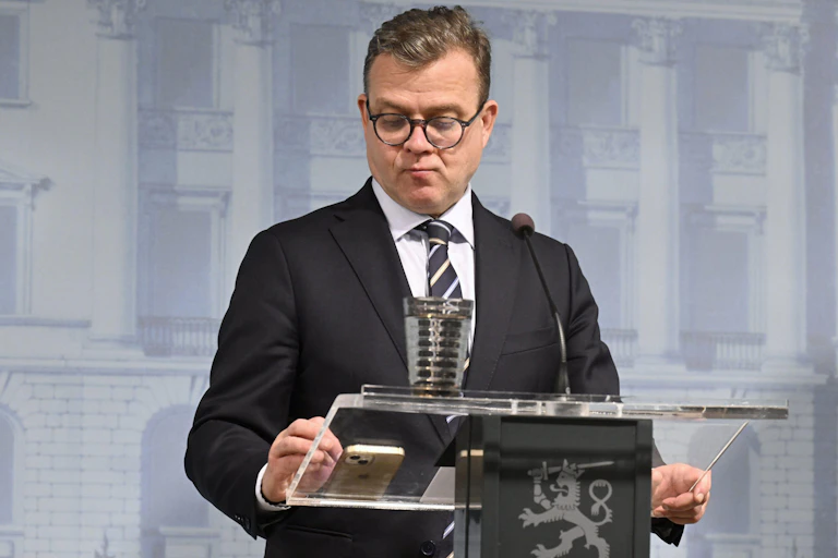 Finnish prime minister Petteri Orpo stands at a podium.