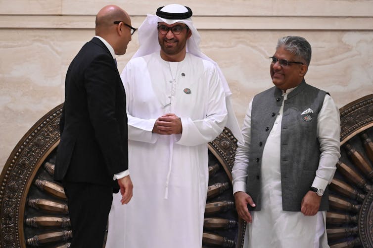 Three men standing and talking.