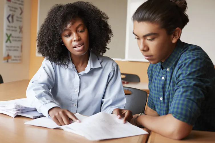 High school tutor gives male student one to one tuition.