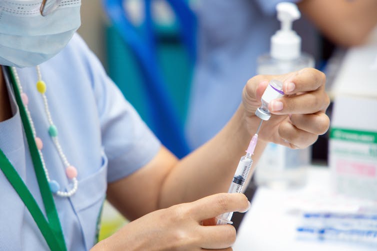 A health-care worker drawing up a vaccine.