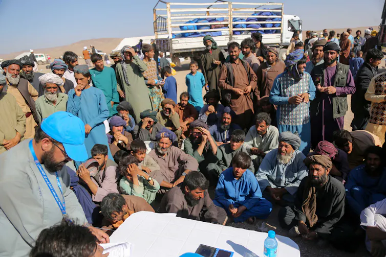 A crowd of Afghan villagers await medical treatment.