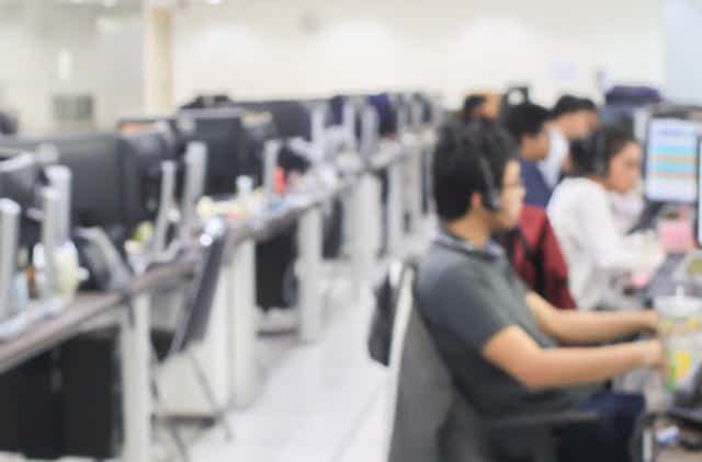 Out-of-focus shot of a call centre with employees at work stations