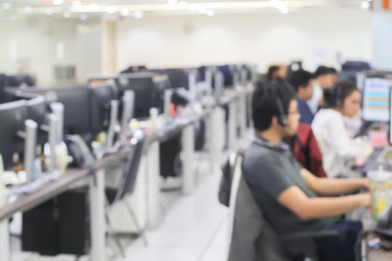 Out-of-focus shot of a call centre with employees at work stations