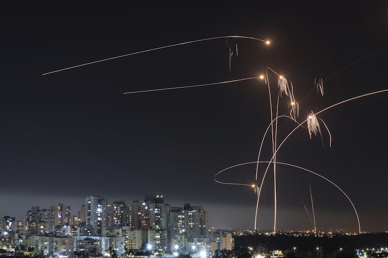 Plumes of light are seen in the night sky.