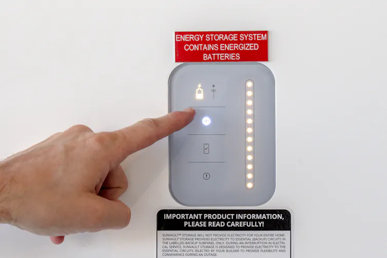 A hand points to a lighted electronic panel.