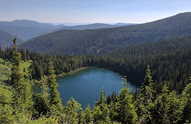 A lake surrounded by forested hills in 