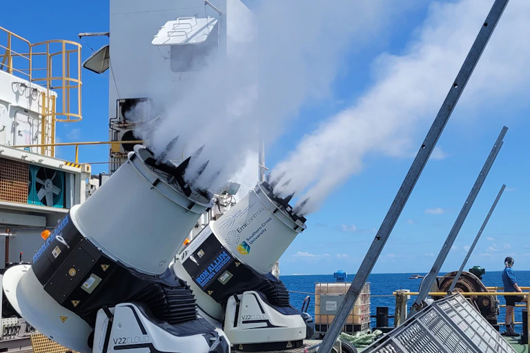 A pair of cloud brightening generators (V model) in action, on board a vessel, with a person nearby