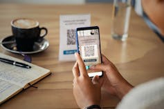 Man checks his Apple Pay app on his phone