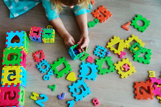 Child playing with numbers and shapes