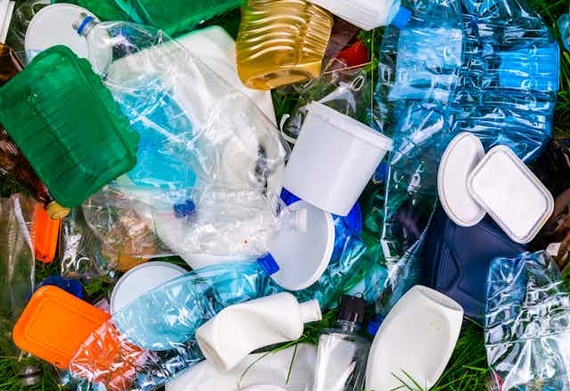 Several plastic containers, from water bottles to tubs to shampoo bottles and lids. 