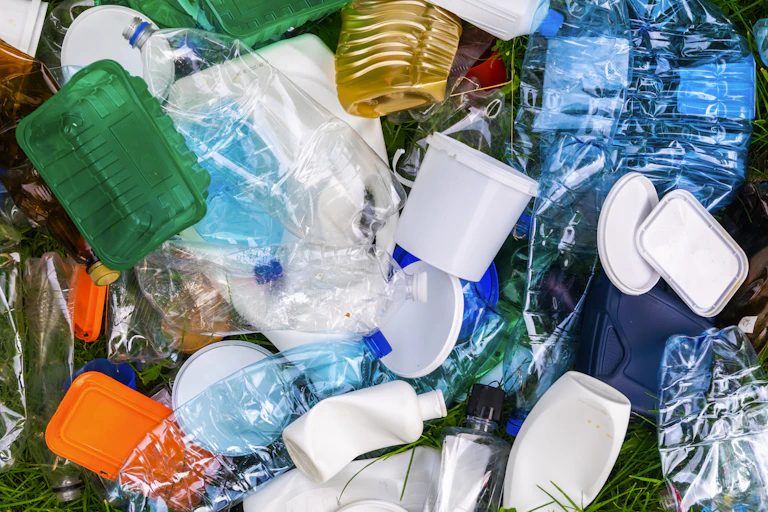 Several plastic containers, from water bottles to tubs to shampoo bottles and lids.
