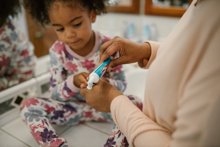 Mum puts toothpaste on daughter's toothbrush