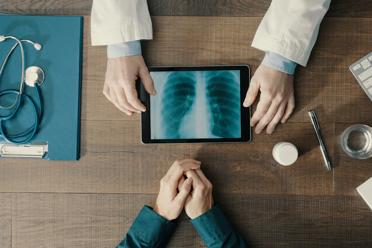 Doctor showing a patient a tablet computer with a chest scan on it