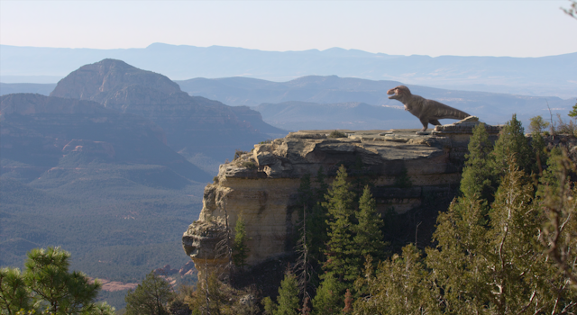 a T-rex standing on a cliff edge. 