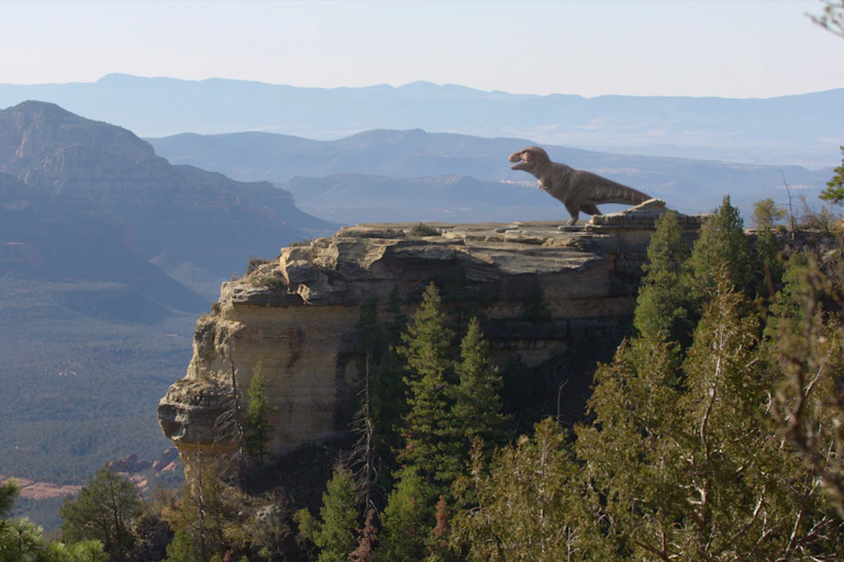 a T-rex standing on a cliff edge.