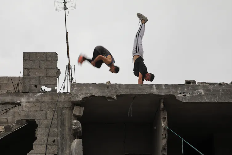 Palestinian youths do parkour in the ruins of a bombed buildiong on the Gaza strip.