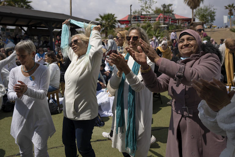 Women dance, clap and laugh.