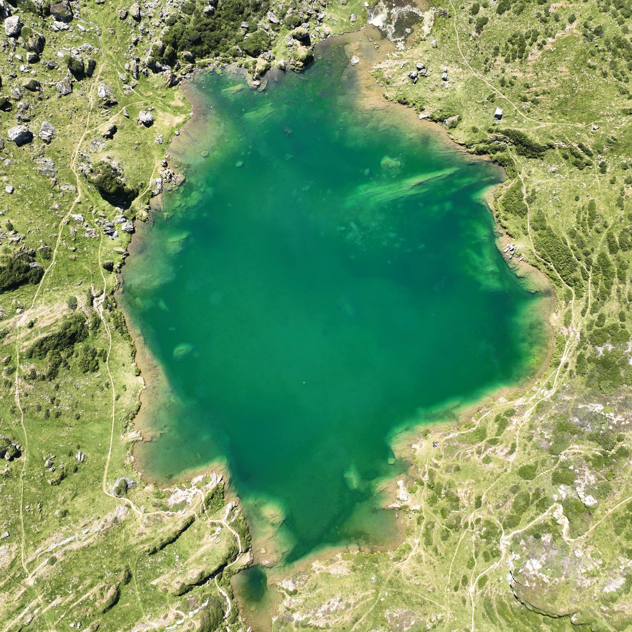aerial view of a green mountain lake